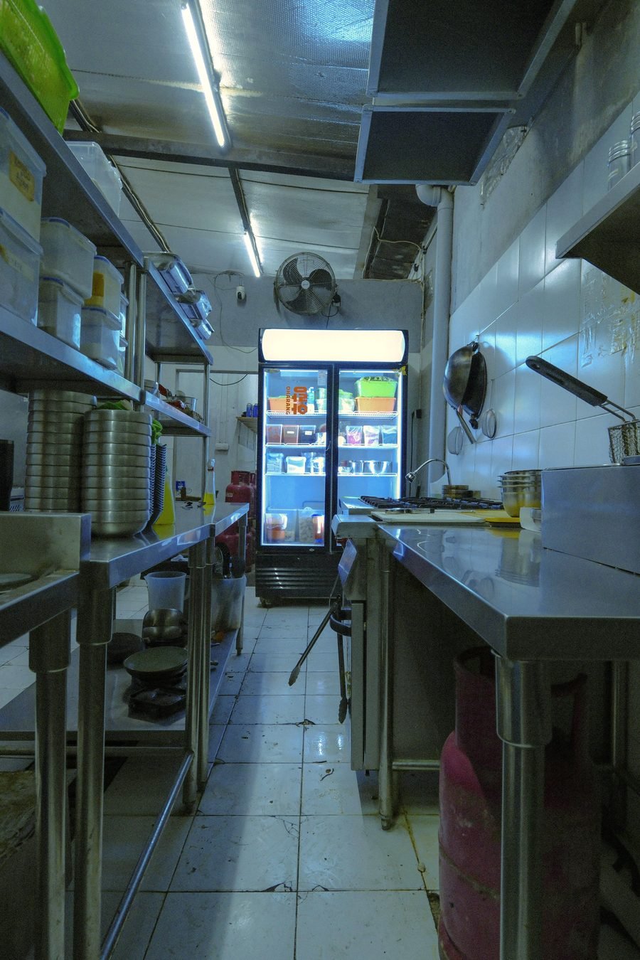 Stainless steel refrigeration and prep counters in a restaurant kitchen.