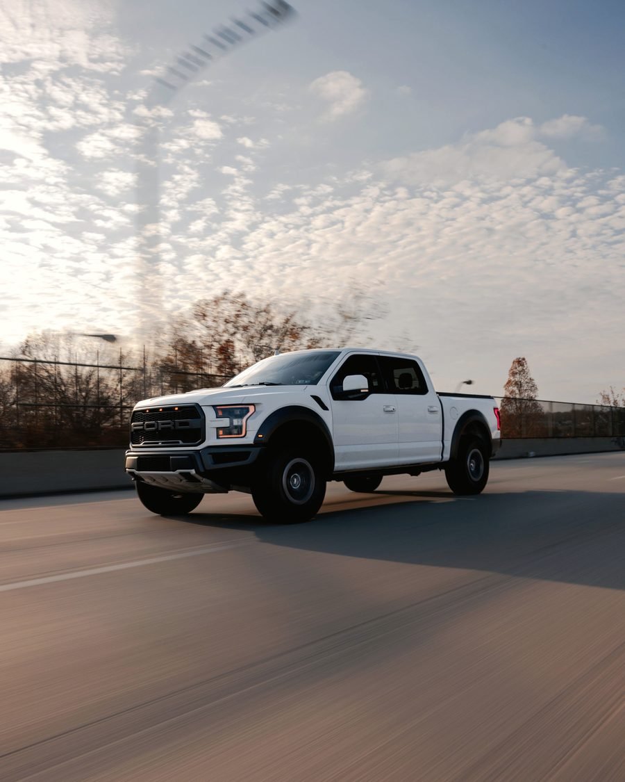 A white service pickup truck on the road.